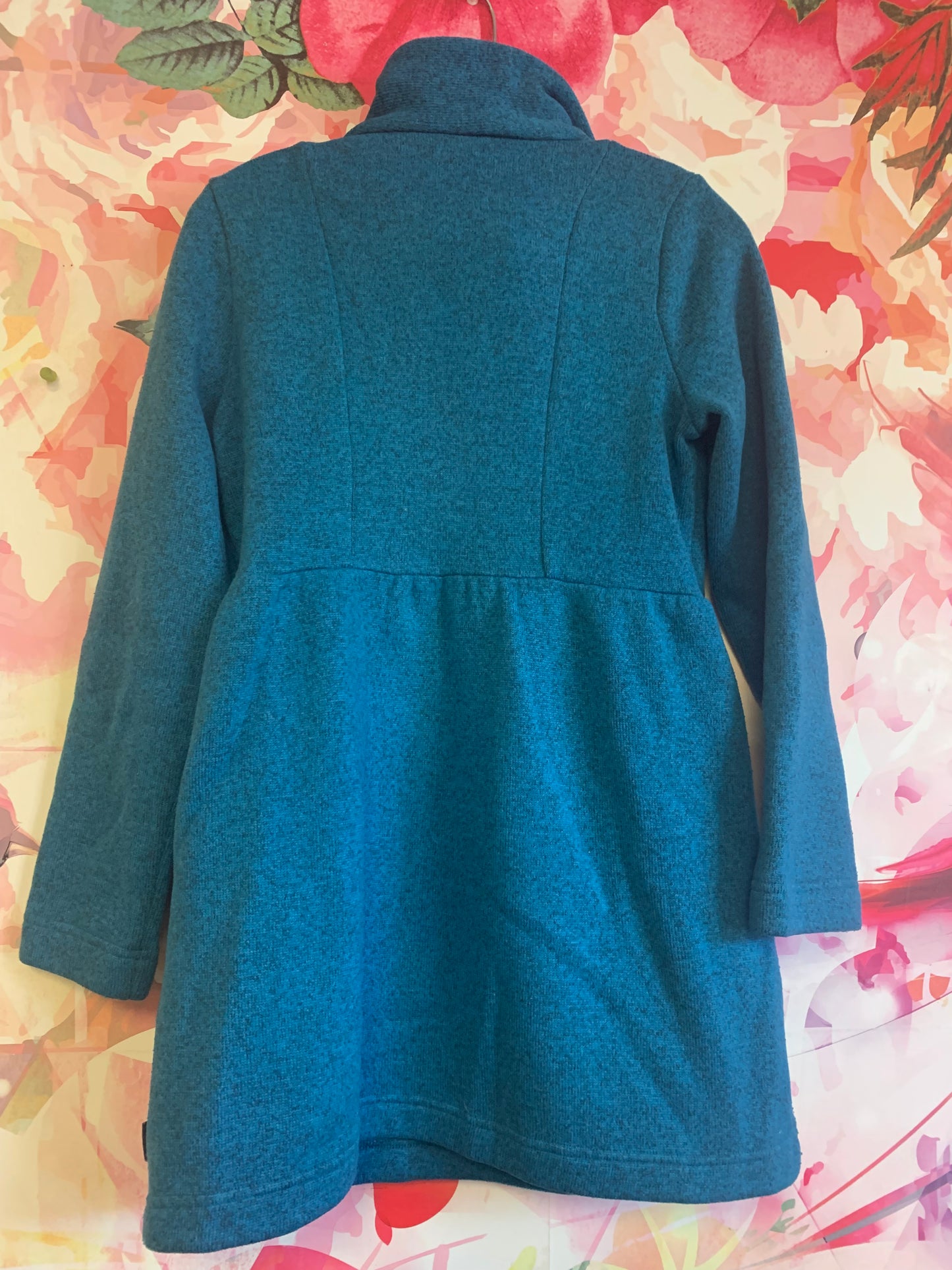 Patagonia blue jacket with button collar, pockets and slight flare on bottom. Size 16/18.