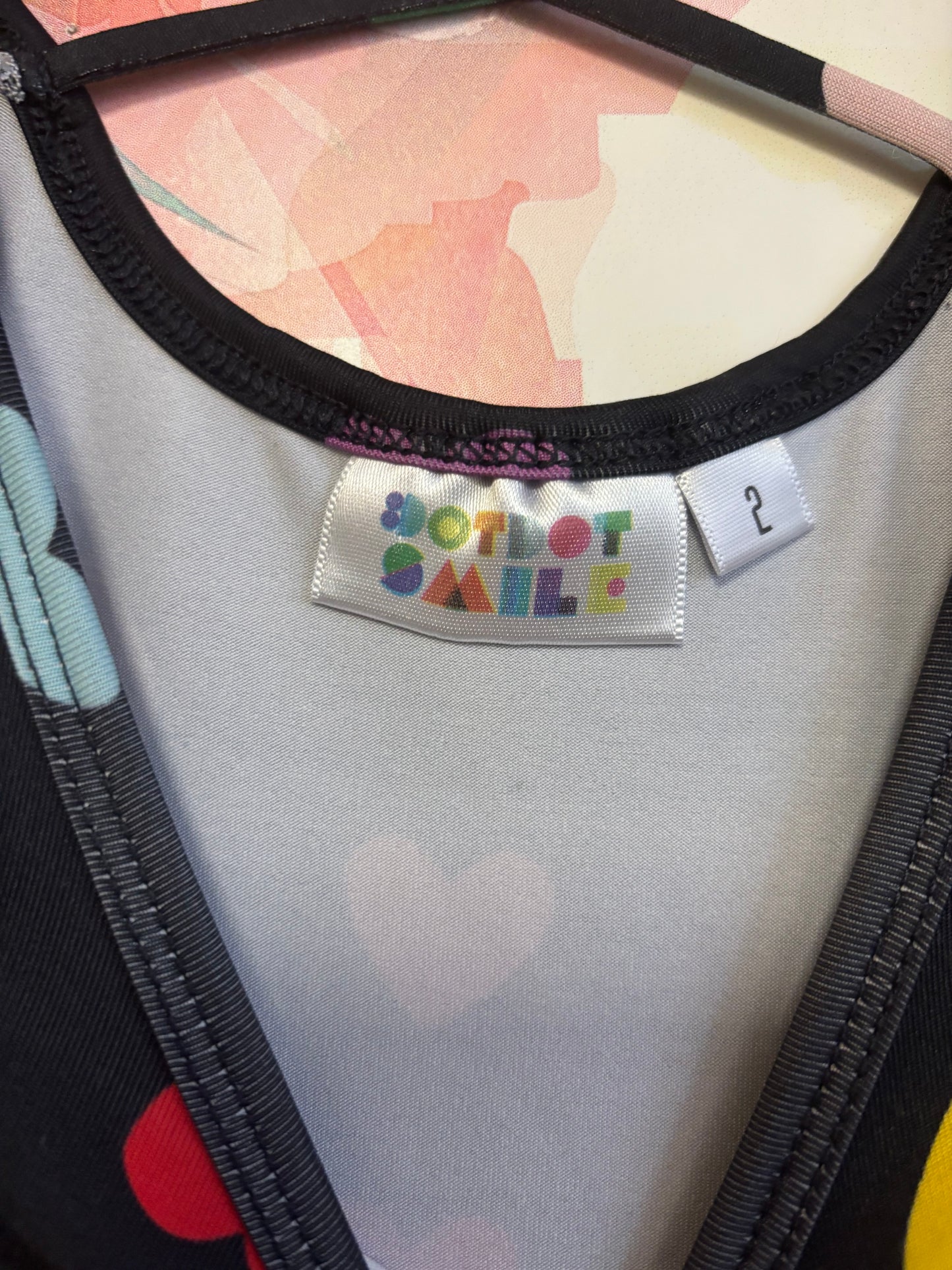 Dot Dot Smile black short sleeve swing dress with rainbow hearts and criss cross back. Size 2T.