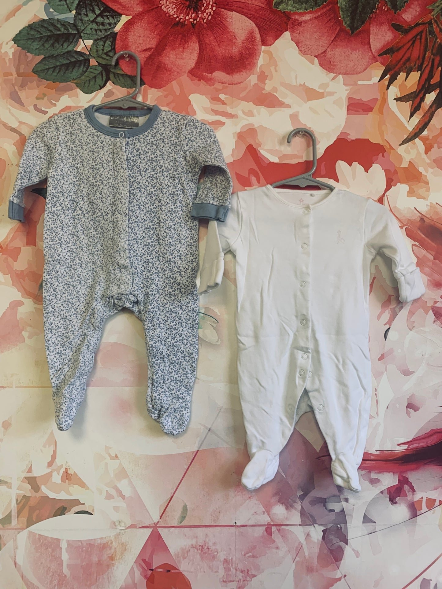 Two long sleeve rompers with snaps. Rock A Bye Baby blue & white flower romper. Size 3-6m. Next Baby white romper. Size 3m