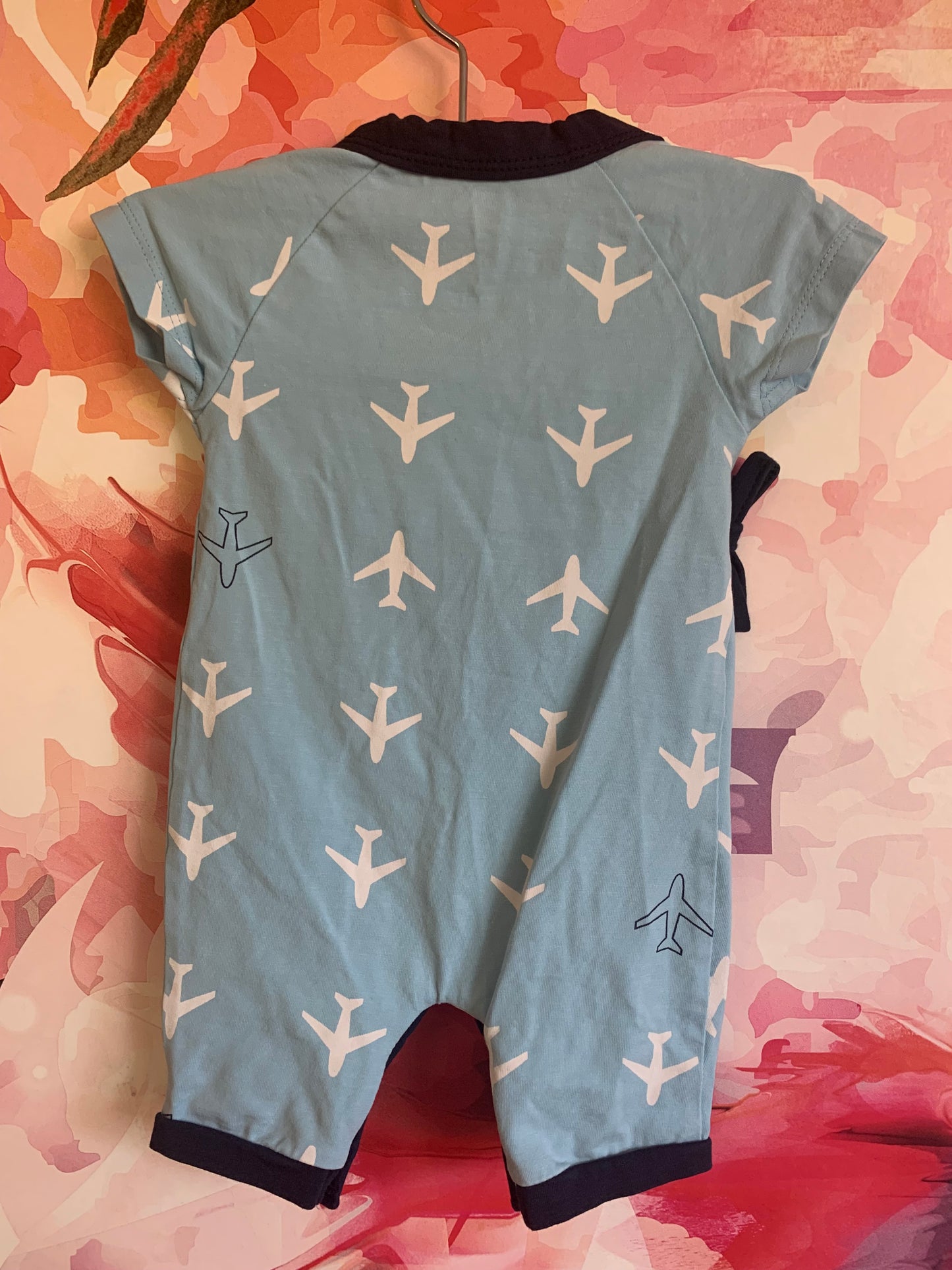 Monica & Andy blue kimono tie short sleeve one piece with white planes. 95% organic cotton 5% spandex. Lead, phthalate & flame-retardant free. Size 0-3m / NB