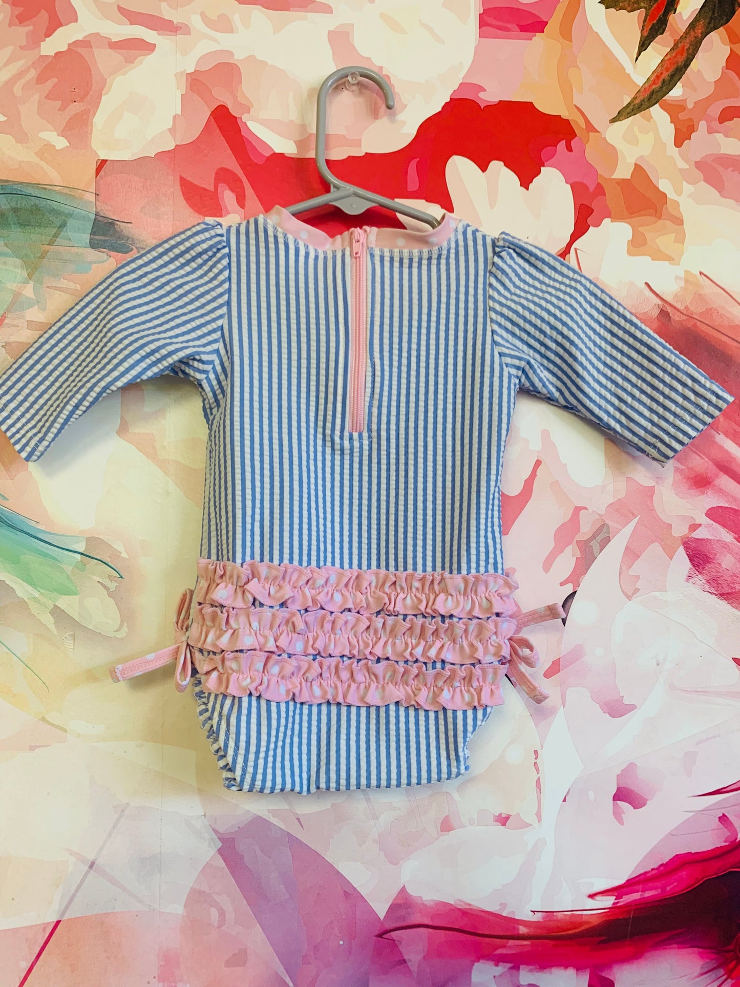 Ruffle Butts blue/white stripe long sleeve swimsuit with pink/white polka dot piping, ruffle and bows. Size 0-3m / NB
