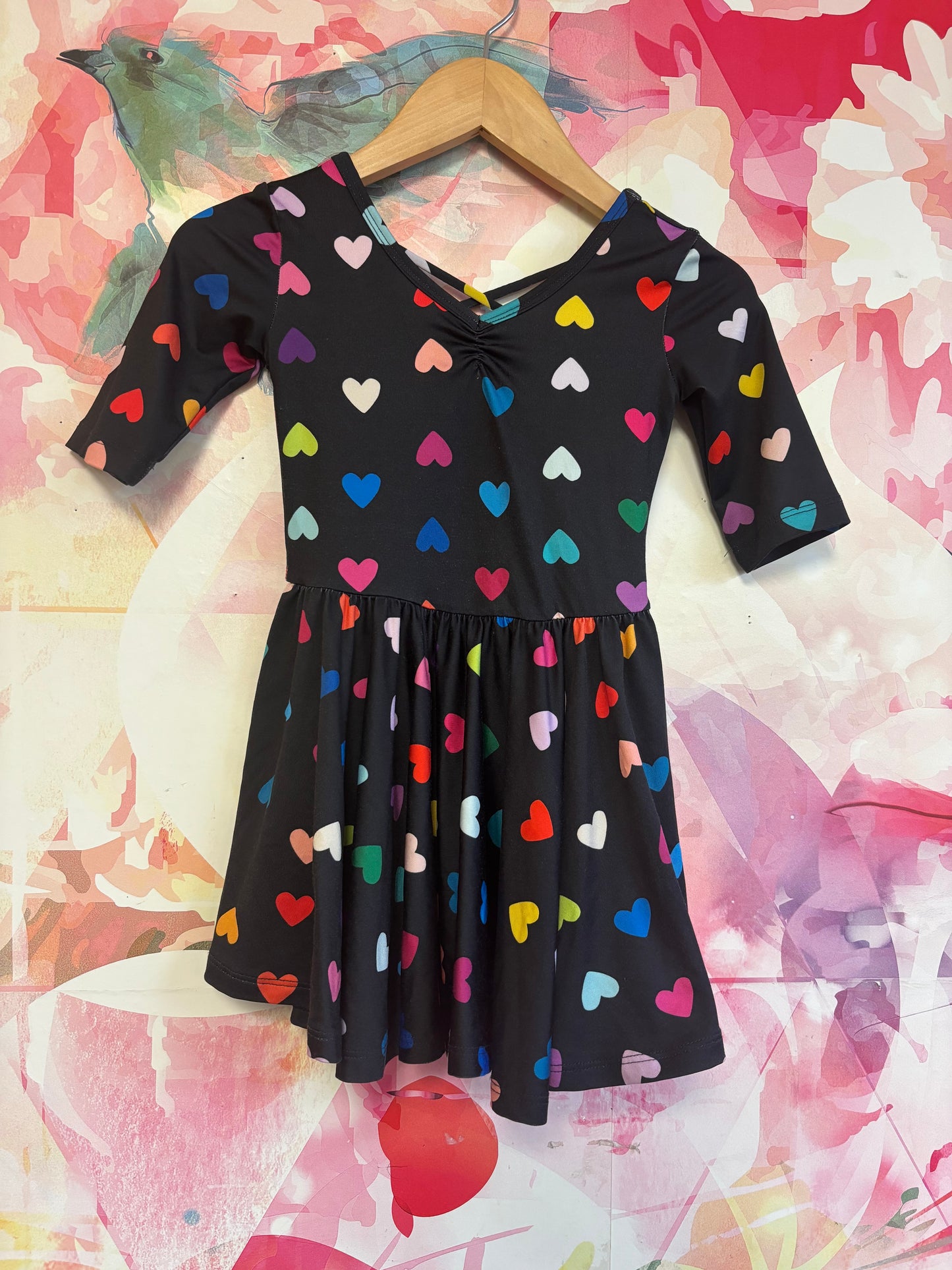 Dot Dot Smile black short sleeve swing dress with rainbow hearts and criss cross back. Size 2T.