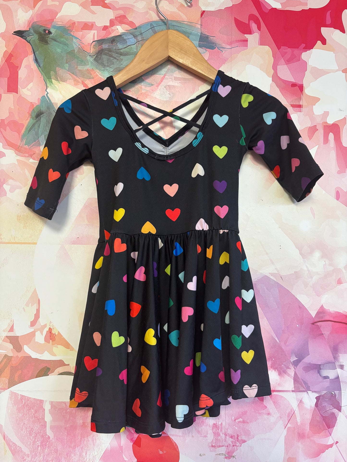 Dot Dot Smile black short sleeve swing dress with rainbow hearts and criss cross back. Size 2T.