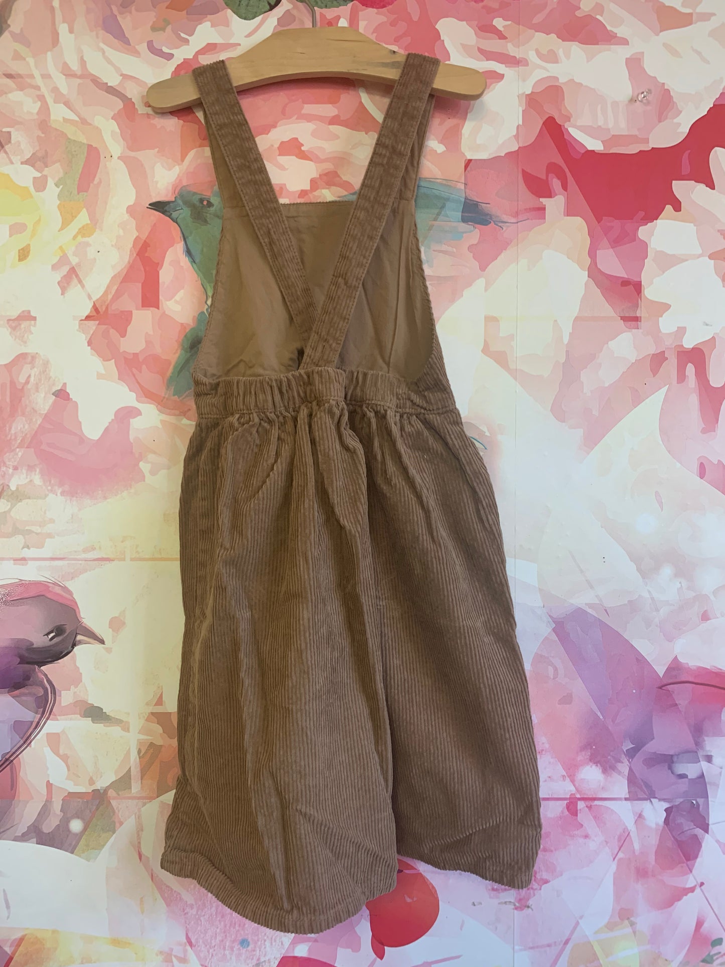 H&M light brown corduroy apron front dress with criss cross straps in back. Size 7.