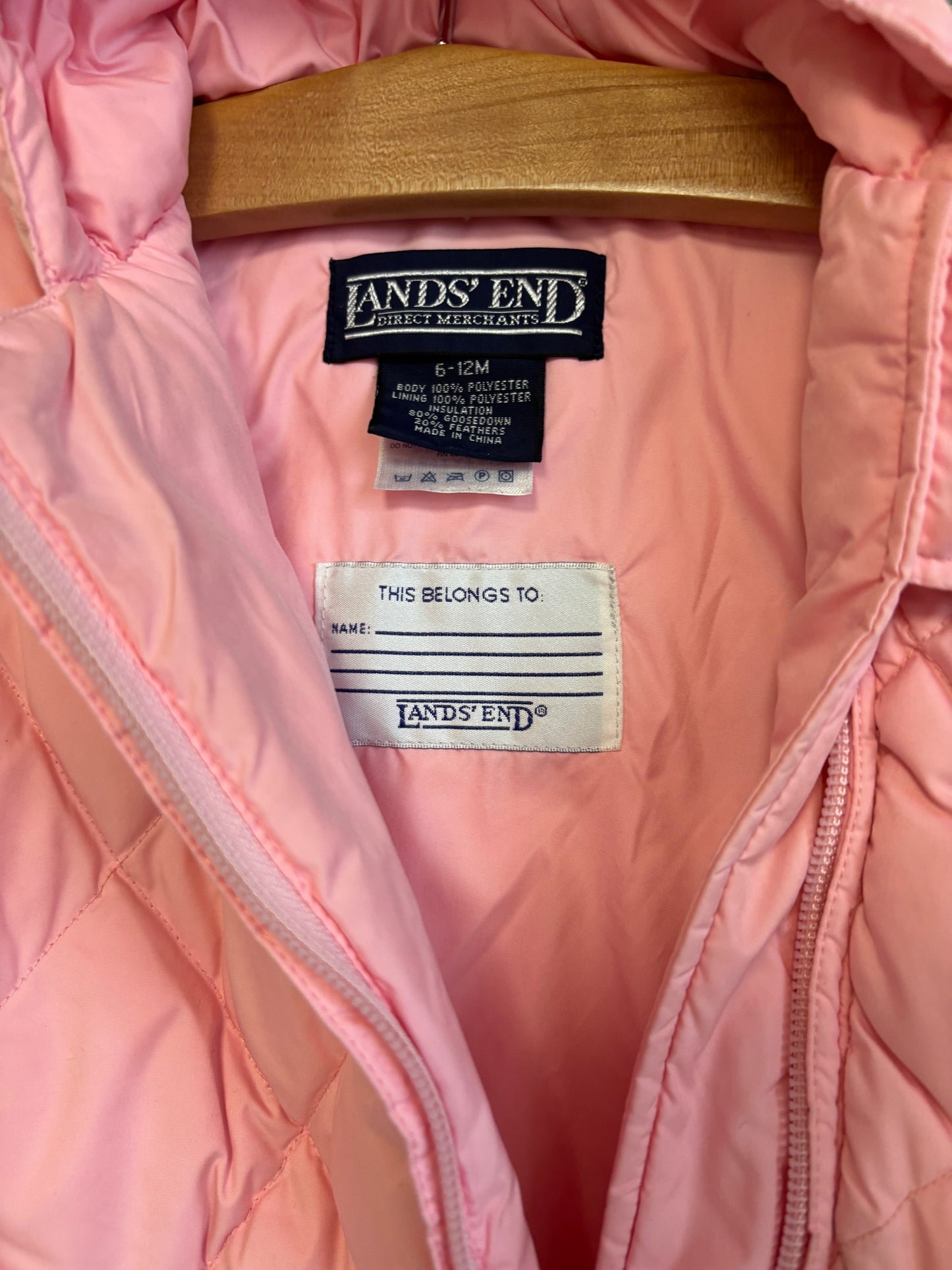Land’s End pink quilted snow suit with hood. Hands & feet fold over. Small stain on back left side. See pic for detail. Size 6-12m.