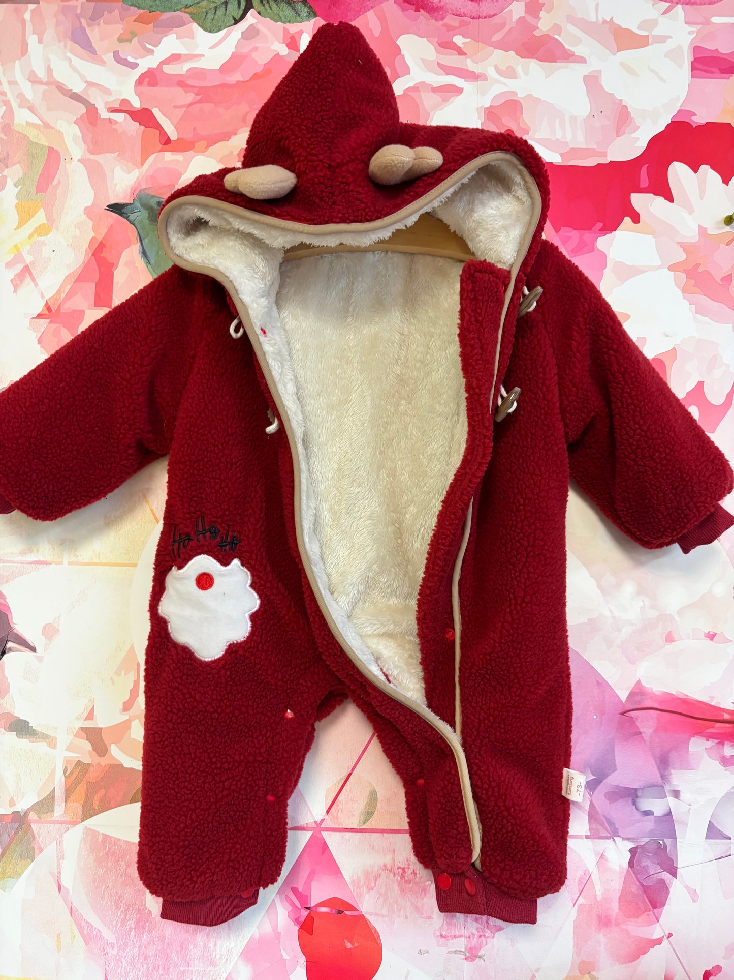 Red fleece faux fur lined bunting with zipper & toggle buttons. Hood has reindeer antlers. Ho Ho Ho Santa beard on suit. Size 3-6m