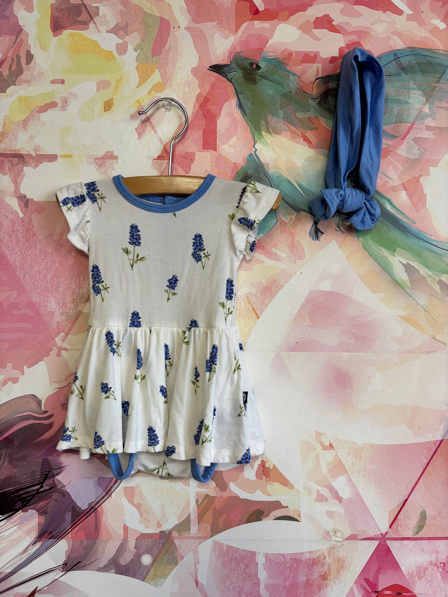 Kyte Baby white dress onesie with blue flowers and blue headband. Made of Bamboo size 0-3m NB