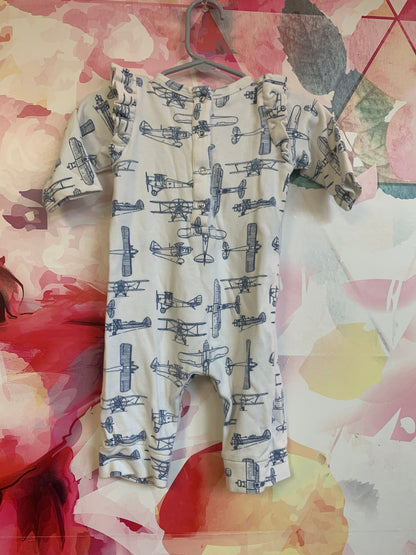 Kate Quinn cream romper with blue airplanes and shoulder ruffles. 100% organic cotton. Size 3-6m