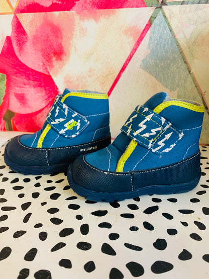 See Kai Run blue & yellow Blake winter boots. Zig zag white arrows on strap. Nylon & textile upper with rubberized PU Rand repels water. Gusseted tongue keeps debris out. Rubber sole built for maximum grip on wet and snowy terrain. Size 6.