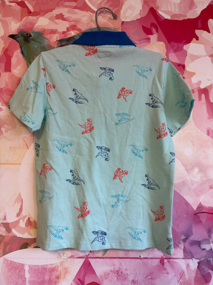 Maximus Rex light blue short sleeve polo with orange and blue dinosaur outlines. Size 7.