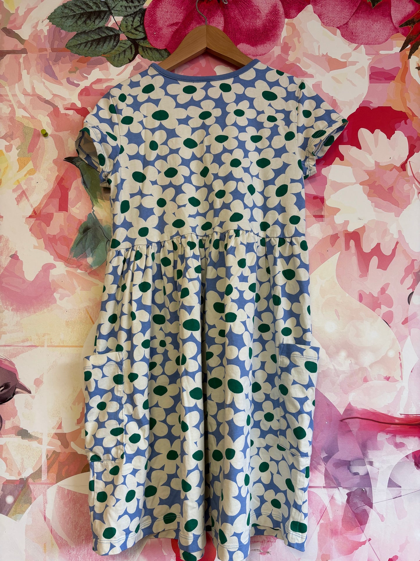 Short sleeve blue dress with white and green flowers and front pockets. Size 12