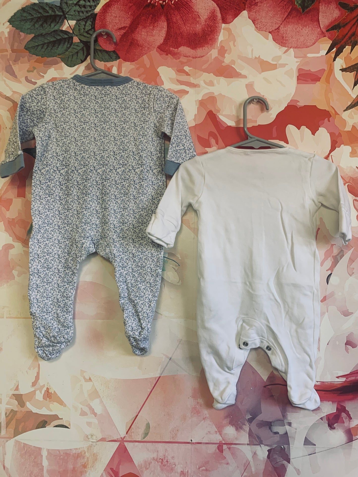 Two long sleeve rompers with snaps. Rock A Bye Baby blue & white flower romper. Size 3-6m. Next Baby white romper. Size 3m.