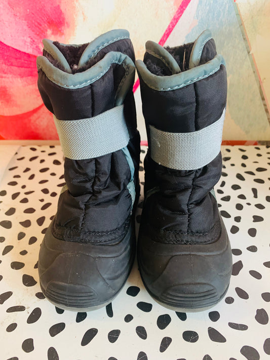 Kamik Snowbug black kids winter boots. Foam & fur Insulation. Waterproof nylon upper. Easy on wide opening & adjustable elastic strap. Moisture wicking soft faux fur lining. Great for all-day outdoor play. Size 7.