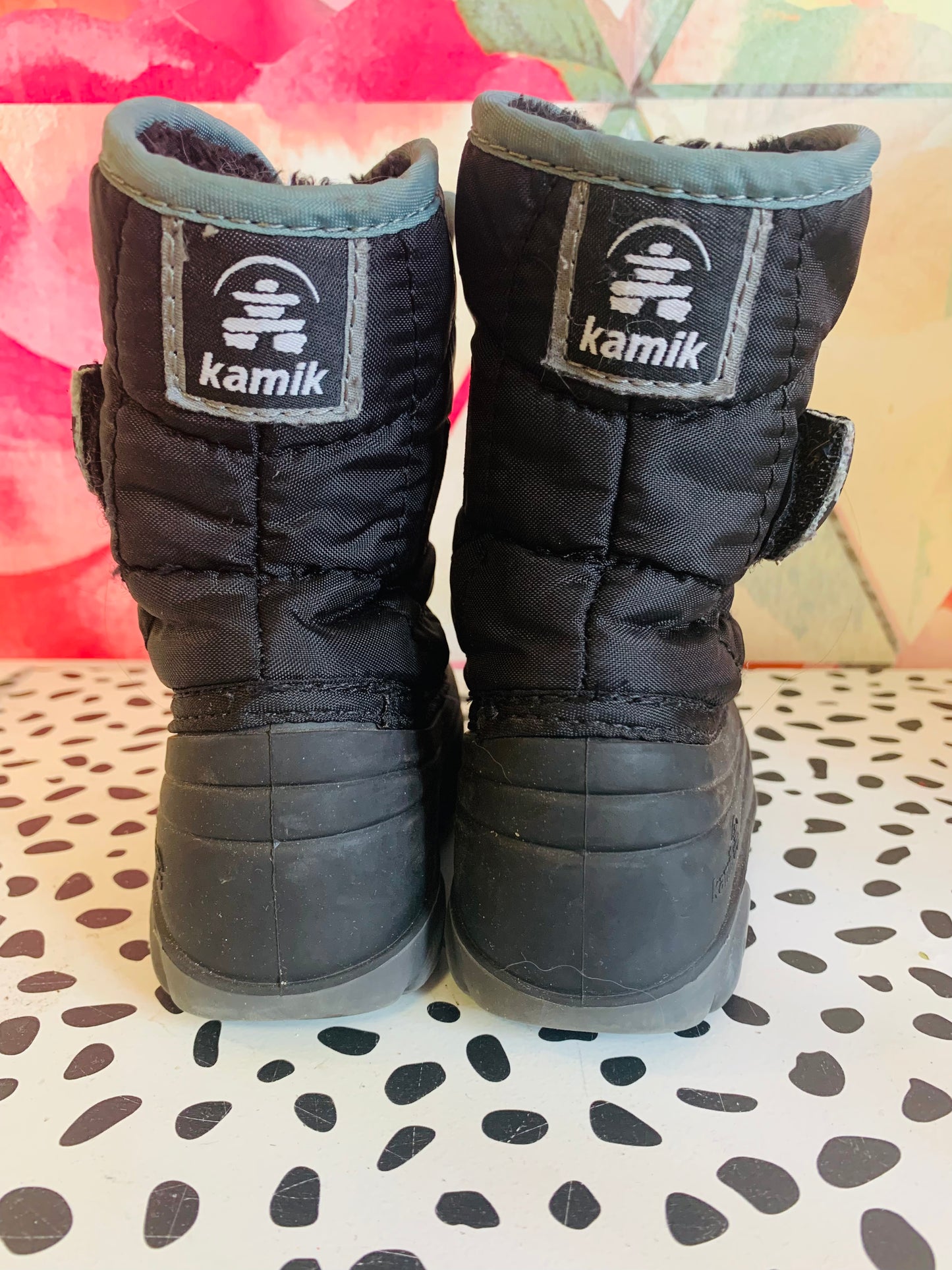 Kamik Snowbug black kids winter boots. Foam & fur Insulation. Waterproof nylon upper. Easy on wide opening & adjustable elastic strap. Moisture wicking soft faux fur lining. Great for all-day outdoor play. Size 7.