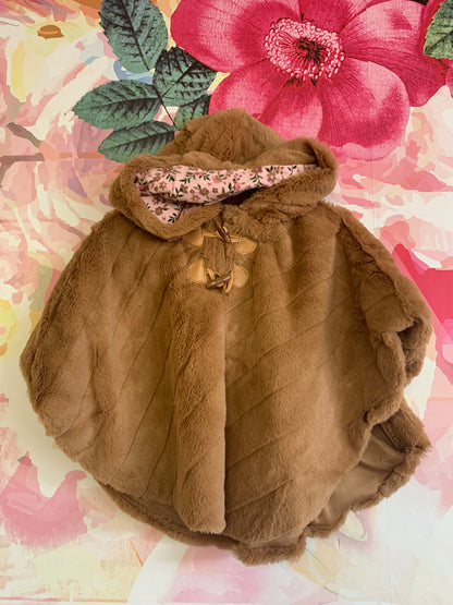 Little Lass light brown faux fur poncho with hood and side snaps. Pink floral lining. Size 18m.