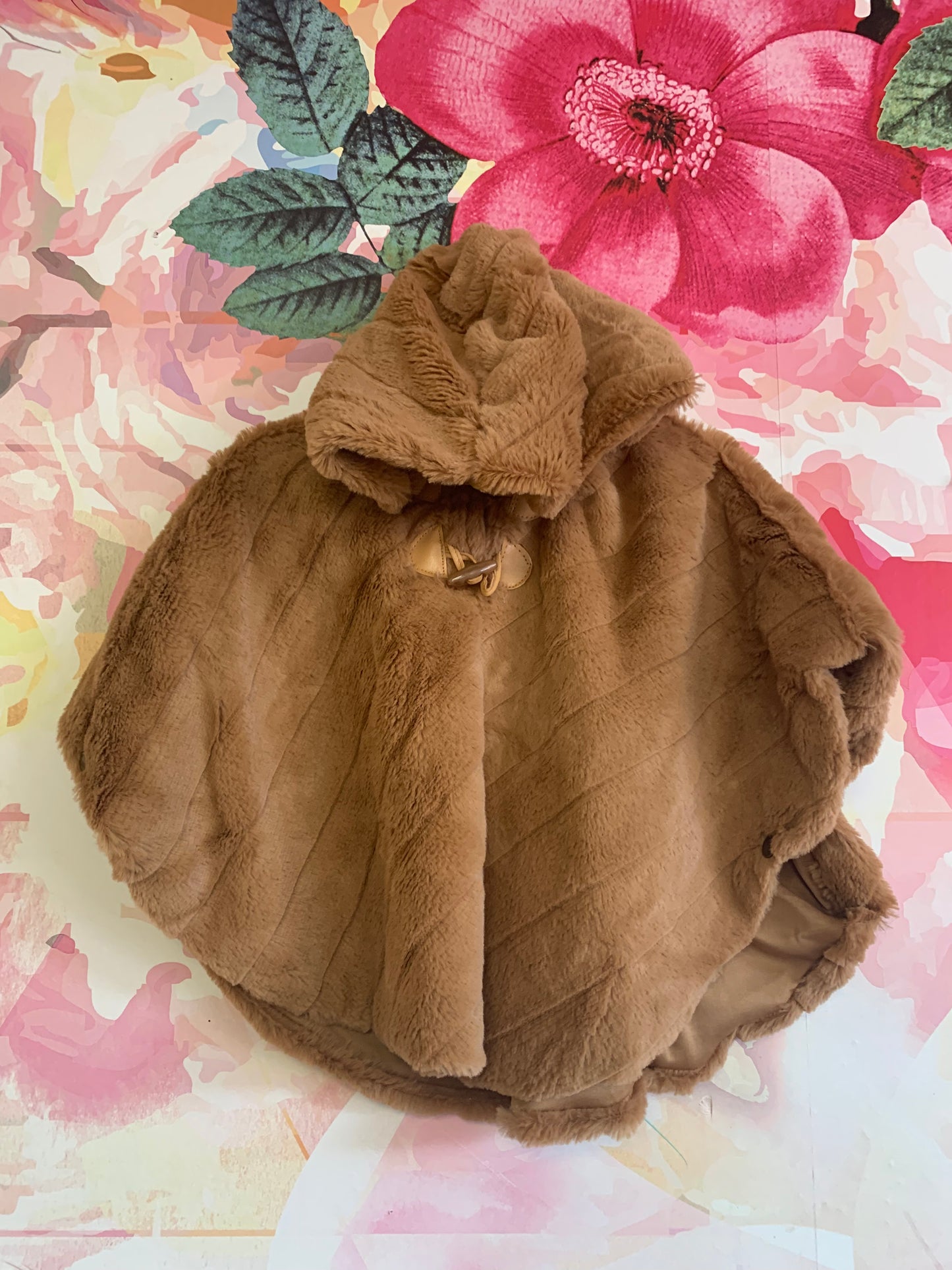 Little Lass light brown faux fur poncho with hood and side snaps. Pink floral lining. Size 18m.